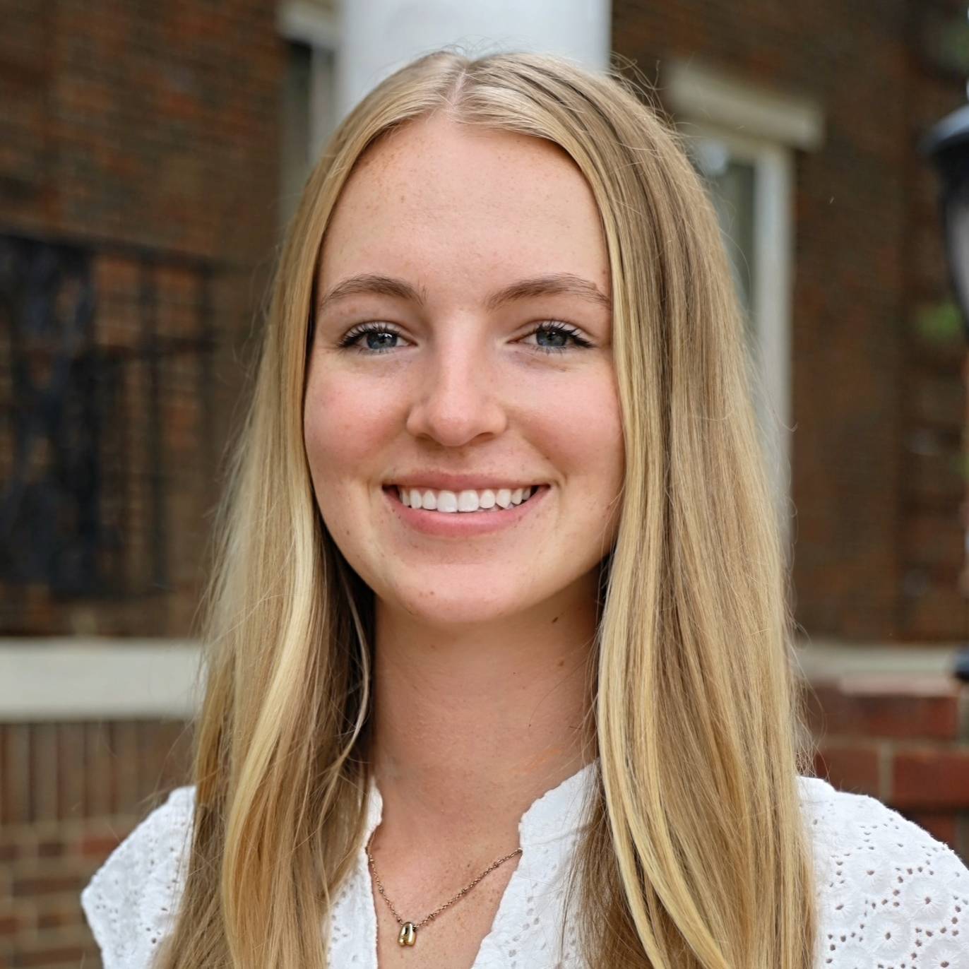 white woman smiling in white shirt with blonde hair