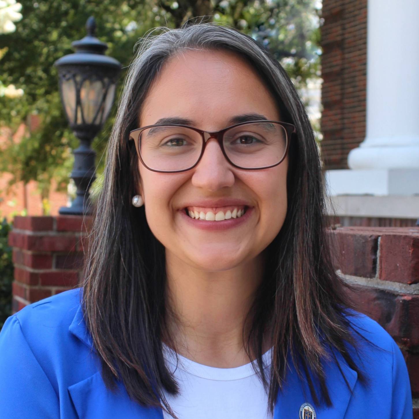 woman in glasses and blue and white shirt smiling
