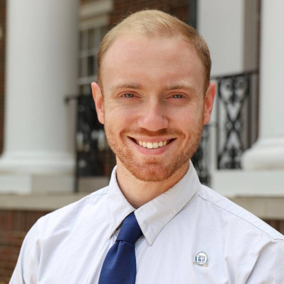 white male smiling in white shirt and tie