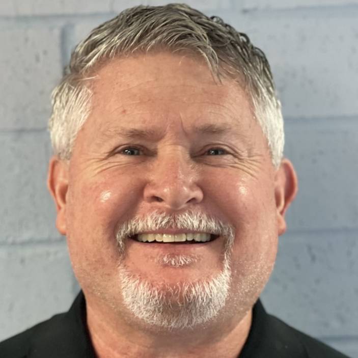 man in black polo smiling